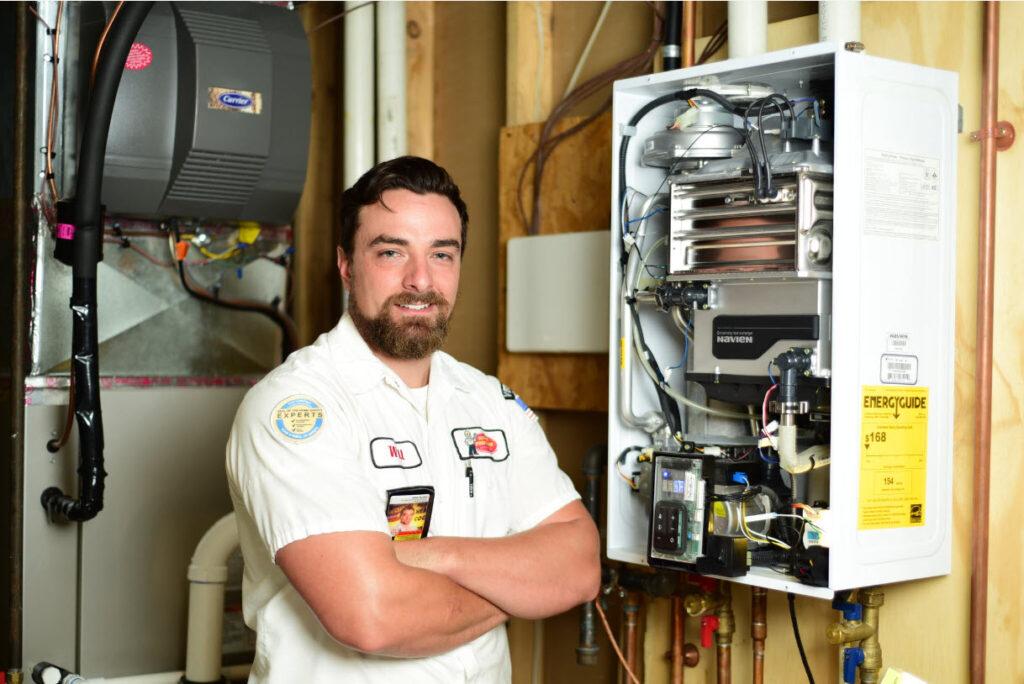 Service Professor plumber next to a tankless water heater