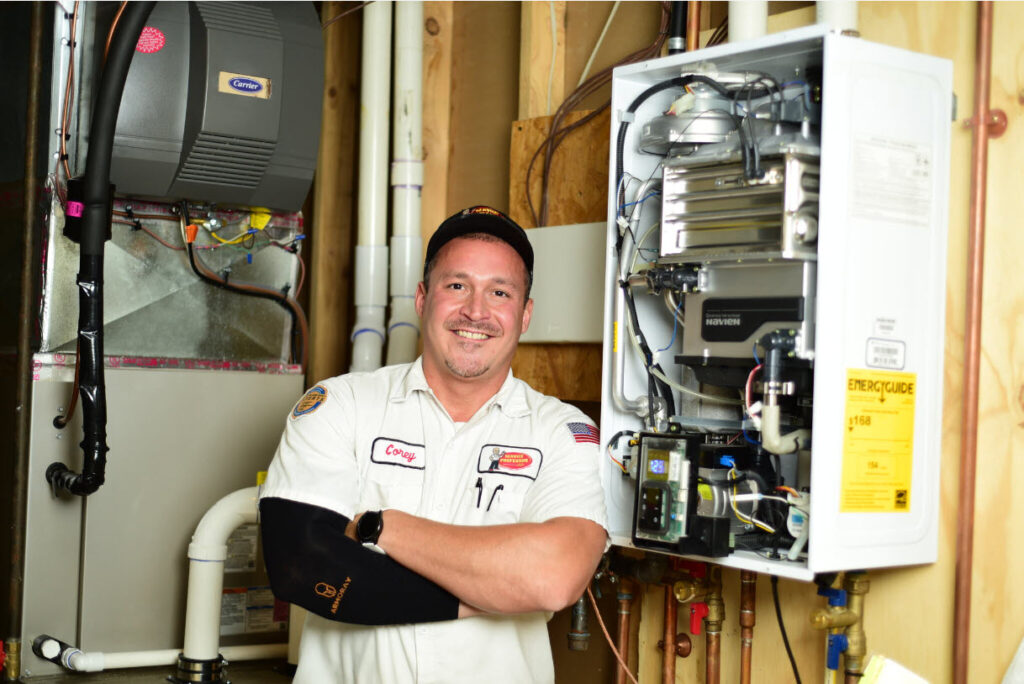 Service Professor plumber in front of a tankless water heater