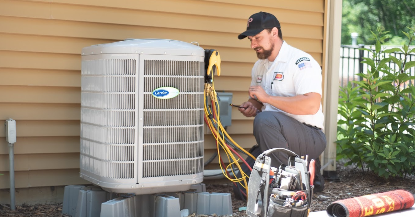 AC technician performing maintenance on an air conditioner unit outside a home.