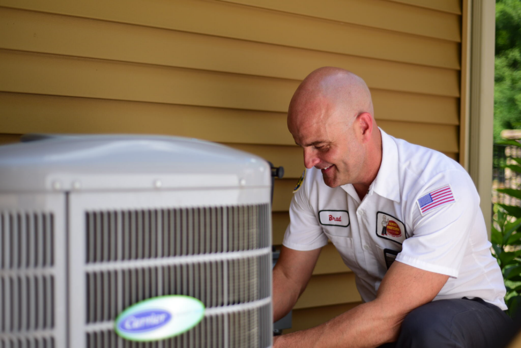 Service Professor AC technician repairing an air conditioner outside a yellow home