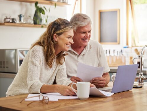 Couple looking at HVAC installation incentives and rebates on their laptop